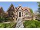Charming brick home with a red-tiled roof and landscaped front yard in a neighborhood setting at 2591 Albion St, Denver, CO 80207