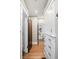 Hallway with hardwood floors, white storage cabinet and multiple doorways to other rooms at 2591 Albion St, Denver, CO 80207