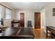Office space with hardwood floors, a large desk, a leather chair, and two dark wooden doors at 2591 Albion St, Denver, CO 80207