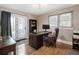Bright office with hardwood floors, a large desk, a bookcase, and a door leading to a patio at 2591 Albion St, Denver, CO 80207
