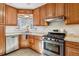 Updated kitchen with stainless steel appliances and wood cabinets at 3151 S Corona St, Englewood, CO 80113