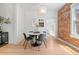 Bright dining room featuring modern lighting, exposed brick wall, and a stylish round table, perfect for cozy meals at 480 S Grant St, Denver, CO 80209