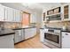 Well-lit kitchen features white cabinets, stainless steel appliances, and stone countertops at 480 S Grant St, Denver, CO 80209