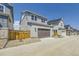 A two-car garage with a brown door and light gray siding set in a new community with blue sky above at 2702 E 103Rd Ave, Thornton, CO 80229