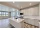 Bright kitchen featuring white cabinets, quartz countertops, stainless steel appliances, and a center island at 2702 E 103Rd Ave, Thornton, CO 80229