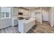 Modern kitchen features white cabinets, quartz countertops, stainless appliances, and a kitchen island at 2702 E 103Rd Ave, Thornton, CO 80229