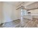 Open concept living and dining area with modern lighting, light wood floors, and a kitchen at 2702 E 103Rd Ave, Thornton, CO 80229