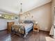 Cozy bedroom features hardwood floors, chandelier lighting, and windows that let in natural light at 34075 Grouse Ln, Evergreen, CO 80439