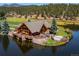 Striking waterfront log cabin with a stone base, decks, and manicured landscape, perfect for a lakeside event at 34075 Grouse Ln, Evergreen, CO 80439