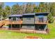 Exterior view of home with multiple decks and mature landscaping at 34075 Grouse Ln, Evergreen, CO 80439