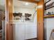 Laundry room featuring a stacked washer/dryer in a closet and open shelving for organizing supplies at 34075 Grouse Ln, Evergreen, CO 80439