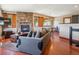 Open concept living room with stone fireplace, wood floors, large sofa and dining area with scenic views at 34075 Grouse Ln, Evergreen, CO 80439