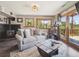 Living room with a stone fireplace, a wood barrel coffee table, and a walk-out patio with nature views at 34075 Grouse Ln, Evergreen, CO 80439