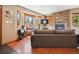 Comfortable living room with wood floors, stone fireplace, large windows, and a scenic view of trees at 34075 Grouse Ln, Evergreen, CO 80439