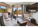 Cozy living room featuring natural light, neutral tones, deck access and a wood-barrel coffee table at 34075 Grouse Ln, Evergreen, CO 80439