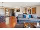 Open concept living room with wood floors, comfortable sofa, and view to the kitchen at 34075 Grouse Ln, Evergreen, CO 80439