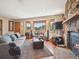 Cozy living room with a stone fireplace, bay window offering views, and comfortable seating arrangements at 34075 Grouse Ln, Evergreen, CO 80439