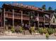A rustic restaurant with balconies, plants, and a 'Little Bear' sign with bear decorations on the roof at 34075 Grouse Ln, Evergreen, CO 80439