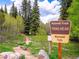 Scenic trailhead with a sign for 'Maxwell Falls' surrounded by lush greenery and tall trees at 34075 Grouse Ln, Evergreen, CO 80439