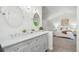 Elegant bathroom features a double vanity with modern fixtures, mirrors, and opens to the bedroom at 13701 Yank Way, Arvada, CO 80004