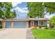 Charming two-story home featuring a well-manicured lawn, large driveway, solar panels, and inviting front entrance at 13701 Yank Way, Arvada, CO 80004