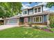 Charming two-story home with a well-manicured lawn, brick accents, and colorful flower beds at 13701 Yank Way, Arvada, CO 80004
