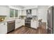 Bright kitchen features white cabinets, stainless appliances, and a farm style sink at 13701 Yank Way, Arvada, CO 80004