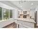 Bright kitchen features white cabinets, stainless appliances, and a center island with seating at 13701 Yank Way, Arvada, CO 80004