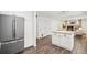 Kitchen featuring a stainless fridge, white cabinets, and an open layout at 13701 Yank Way, Arvada, CO 80004