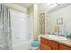 Bright bathroom features a shower and tub combo and a vanity sink with storage at 3595 E 124Th Pl, Thornton, CO 80241