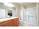 Bathroom with double sinks, wood vanity, and glass-enclosed shower at 3595 E 124Th Pl, Thornton, CO 80241