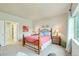 This bedroom features an ensuite bathroom, natural light, and colorful floral decor at 3595 E 124Th Pl, Thornton, CO 80241