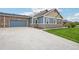 Exterior showcasing blue home with stone accents, garage, and driveway at 3595 E 124Th Pl, Thornton, CO 80241