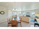 Bright living area with dining table, large windows, neutral tones and chandelier at 3595 E 124Th Pl, Thornton, CO 80241