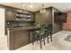 Basement bar with cabinets, shelving, and trendy barstool seating at 6770 Zebra Grass Ln, Parker, CO 80138