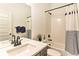 Well-lit bathroom featuring a vanity with a sink, a mirror, and a bathtub with a shower and striped curtain at 6770 Zebra Grass Ln, Parker, CO 80138