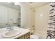 Bright bathroom featuring a shower-tub combo, ample vanity space, and modern fixtures at 6770 Zebra Grass Ln, Parker, CO 80138