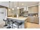 Chic kitchen island with bar stool seating, sleek countertops, and modern lighting fixtures at 6770 Zebra Grass Ln, Parker, CO 80138