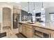 Bright kitchen with stainless steel appliances, island and modern lighting. Open concept to living room at 6770 Zebra Grass Ln, Parker, CO 80138