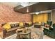 Charming living room showcasing rustic brick wall, plush sofas, and a well-appointed coffee table, great for gatherings at 6770 Zebra Grass Ln, Parker, CO 80138