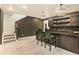 Basement wet bar featuring stylish lighting, dark cabinets, and seating, great for entertaining and relaxation at 6770 Zebra Grass Ln, Parker, CO 80138