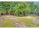 Backyard featuring a mix of open grassy area and mature trees with a wooden privacy fence and chain link fence at 2648 S Wadsworth Way, Lakewood, CO 80227