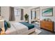 Bright bedroom with natural light from the window, a queen bed with an accent blanket, and sleek closet doors at 2648 S Wadsworth Way, Lakewood, CO 80227