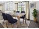 Bright dining room featuring a wooden table set on a patterned rug, bathed in natural light from the large window at 2648 S Wadsworth Way, Lakewood, CO 80227