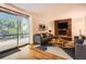 Cozy living room featuring a stone fireplace, hardwood floors, and sliding glass doors at 2648 S Wadsworth Way, Lakewood, CO 80227
