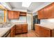 Kitchen with stainless steel sink, wood cabinets, hardwood floors, and black refrigerator at 16835 E Harvard Pl, Aurora, CO 80013