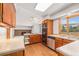 Well-lit kitchen with stainless steel appliances, wood cabinets, hardwood flooring, and backyard view at 16835 E Harvard Pl, Aurora, CO 80013