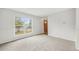 Bright living room featuring gray carpet, large window, and a wooden front door at 16835 E Harvard Pl, Aurora, CO 80013