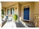 Cozy covered porch with stone accents, comfortable seating, and a bright blue front door at 4968 Montvale Dr, Highlands Ranch, CO 80130