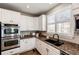 Updated kitchen featuring granite counters, modern appliances, and sleek white cabinets at 4968 Montvale Dr, Highlands Ranch, CO 80130